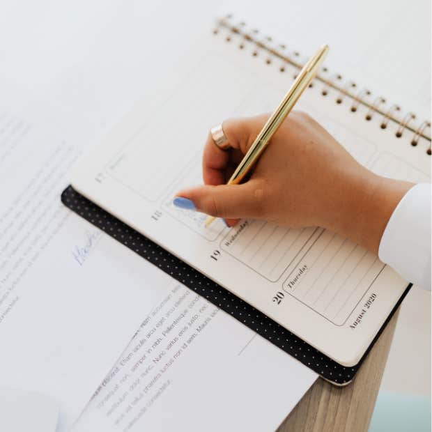 person writing in a planner