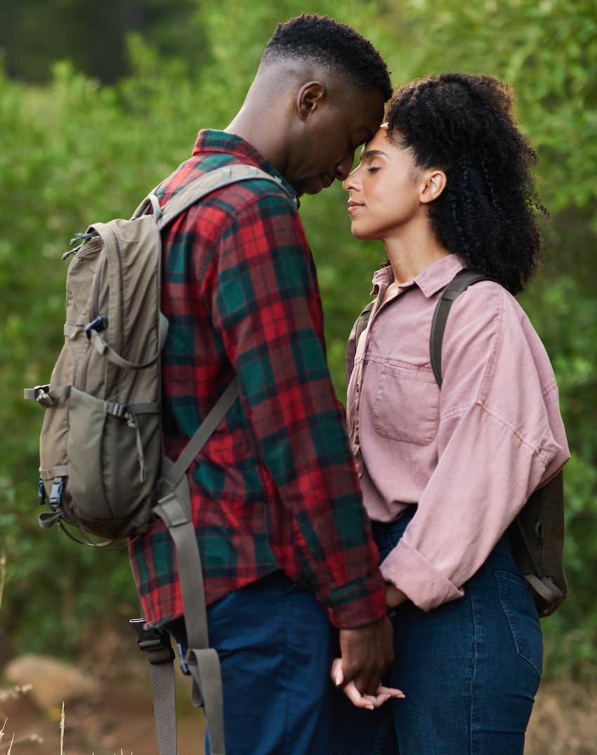 Affectionate couple standing with eyes closed on a hiking trail